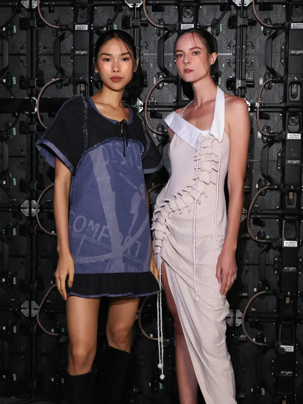 models back stage for a runway wearing two upcycled sustainable high fashion pieces from Rotch.